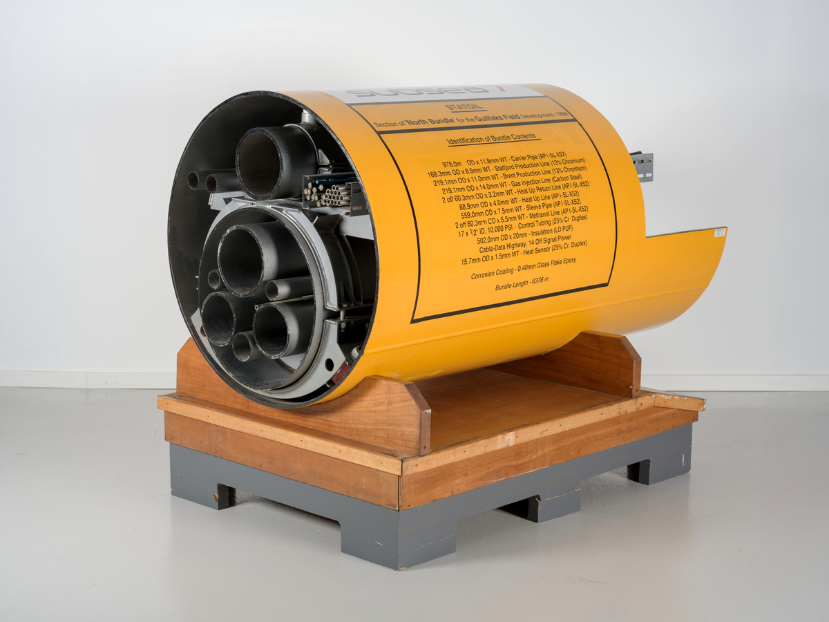 Utstillingsmodell bestående av flere rør som er buntet sammen innvendig i et større rør. Modellen er identisk med rørbunt som ble tatt i bruk på havbunnen på Gullfaks Sør i 1998.