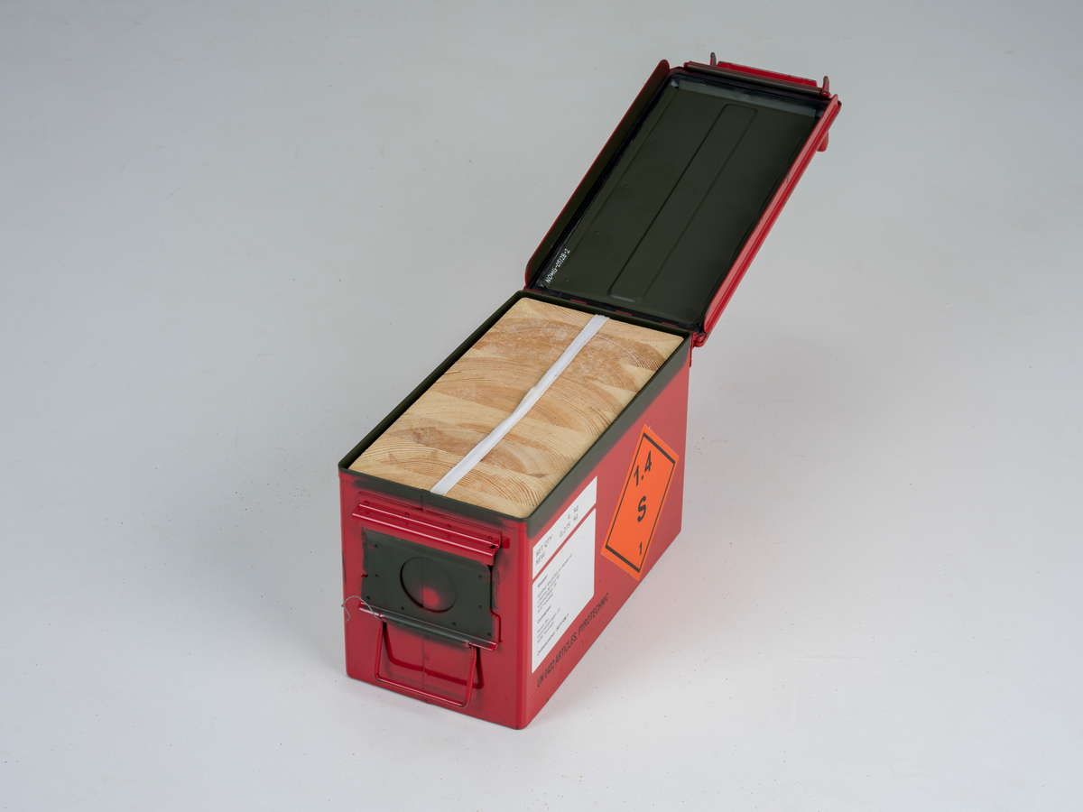 Ammunisjonskasse med hengslet lokk som brukes til å frakte og oppbevare skarp ammunisjon. Innvendig er det en beholder av tre med plass til femti patroner.