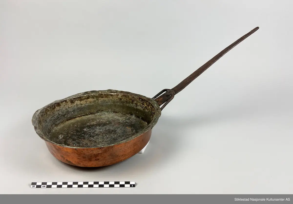 Kobberpanne/kjele med langt skaft. Buet bunn med utstikkende fals i topp/åpning