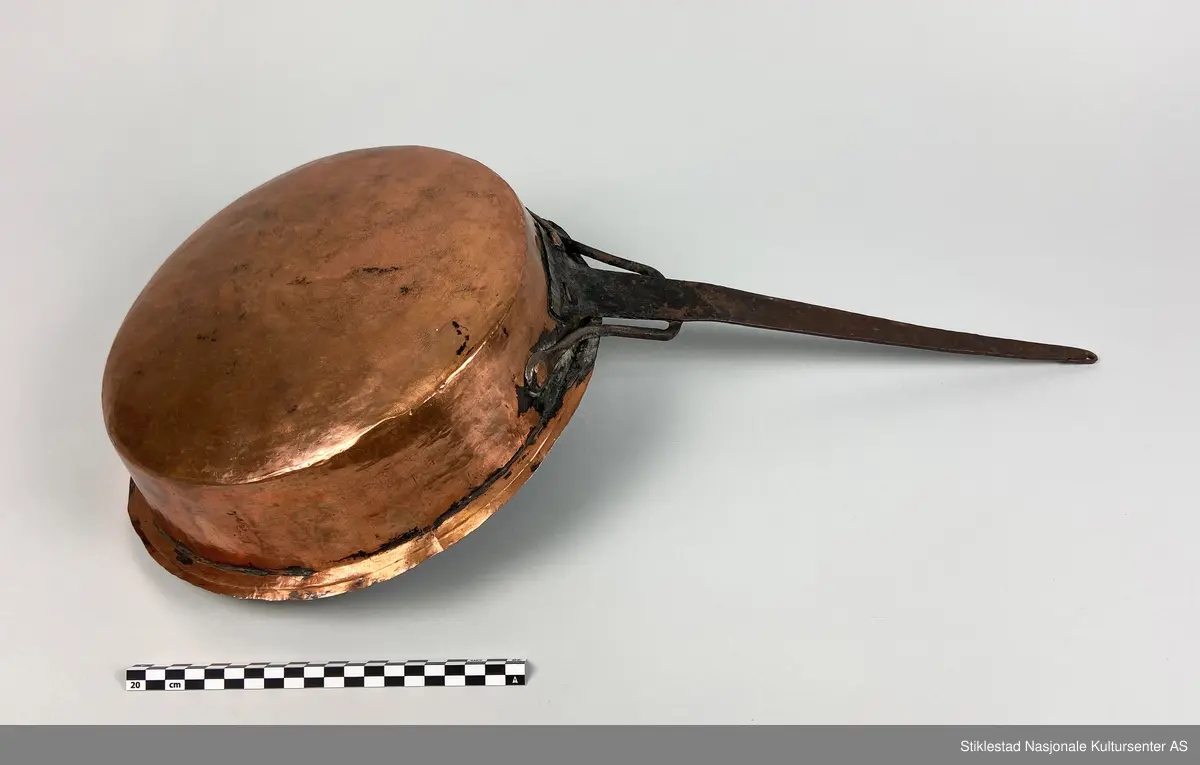 Kobberpanne/kjele med langt skaft. Buet bunn med utstikkende fals i topp/åpning