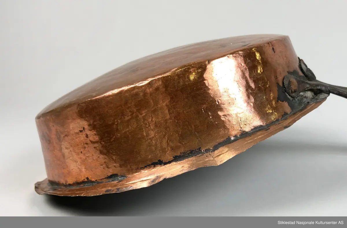 Kobberpanne/kjele med langt skaft. Buet bunn med utstikkende fals i topp/åpning