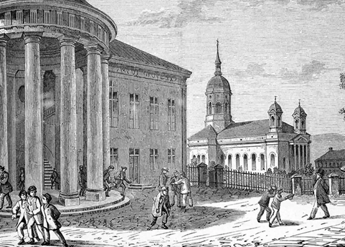 Flera personer på en gårdsplan framför en byggnad med kolonner och en kyrka i bakgrunden.