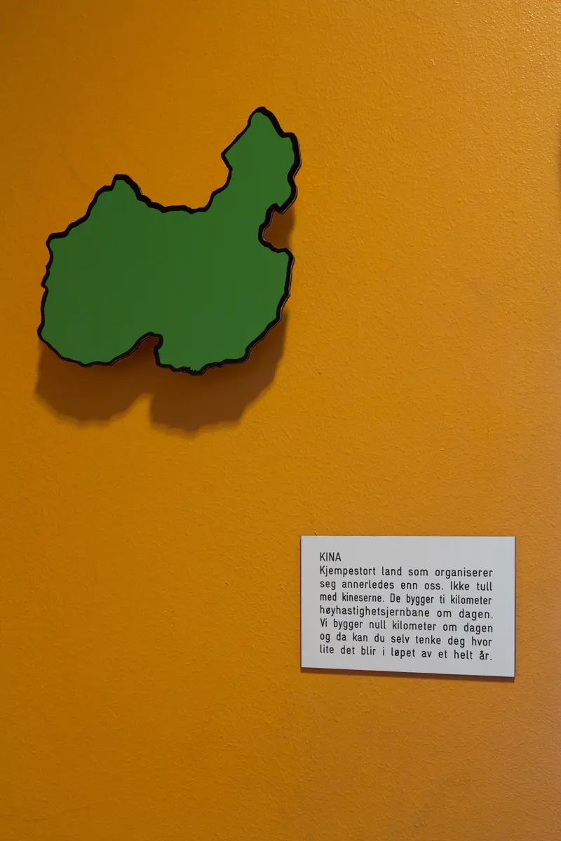 Del av utsmykking på Ranheim skole: en serie med lekne figurer tegnet av Kim Hiorthøy, med tilhørende humørfylte og tankevekkende tekster av Erlend Loe.

KINA
Kjempestort land som organiserer seg annerledes enn oss. Ikke tull med kineserne. De bygger ti kilometer høyhastighetsjernbane om dagen. Vi bygger null kilometer om dagen og da kan du selv tenke deg hvor lite det blir i løpet av et helt år.