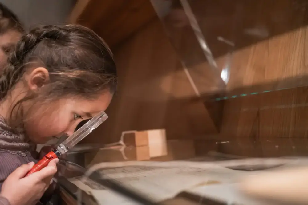 Jente med lupe i utstillinga i Aasentunet 