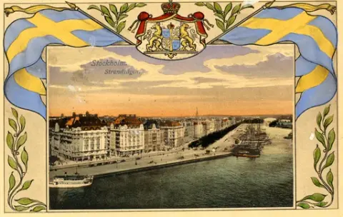 Bild av Strandvägen i Stockholm med båtar som ligger förtöjda och byggnader som radar upp sig längs vägen. Över bilden syns Sveriges riksvapen. Text baksida kort: "Ett hjärligt tack för vad ni sänt, allt gott. Hälsningar John".