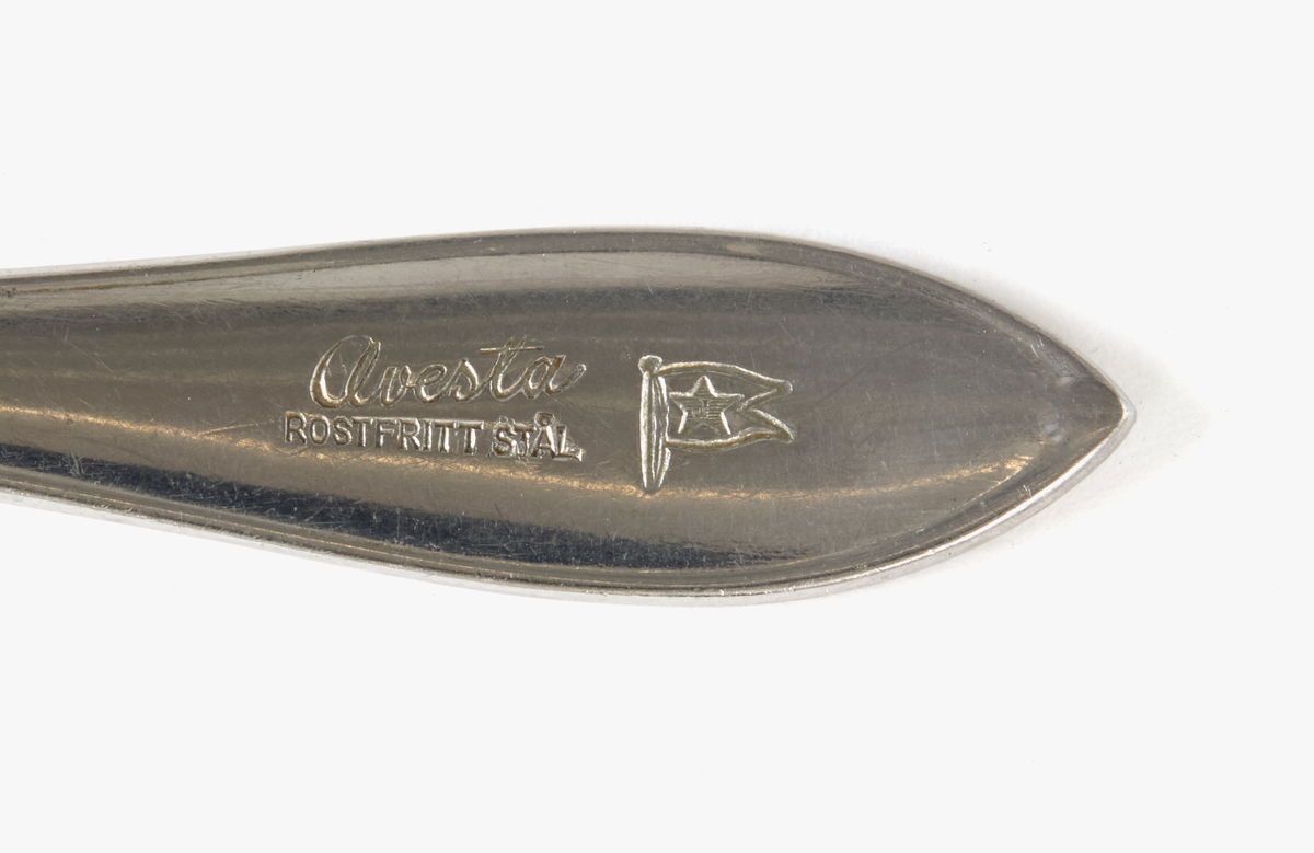 Formstansad sked i rostfritt stål med lätt spetsig skedskål och spetsavslutat skaft. Skaftet stämplat "Avesta rostfritt stål" samt Johnson lines logotyp. Undertill stämplad "rostfri".