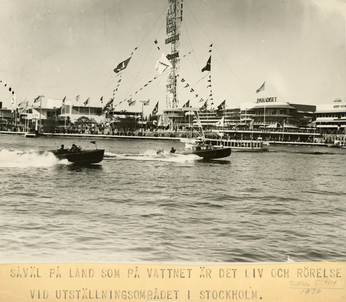 Fotot är taget från Djurgårdsbrunnsviken över Stockholmsutställningen 1930. I området där restaurang Paradiset låg ligger i dag Sjöhistoriska museet. I förgrunden syns två Petterssonbåtar samt en passagerarfärja som passerar.