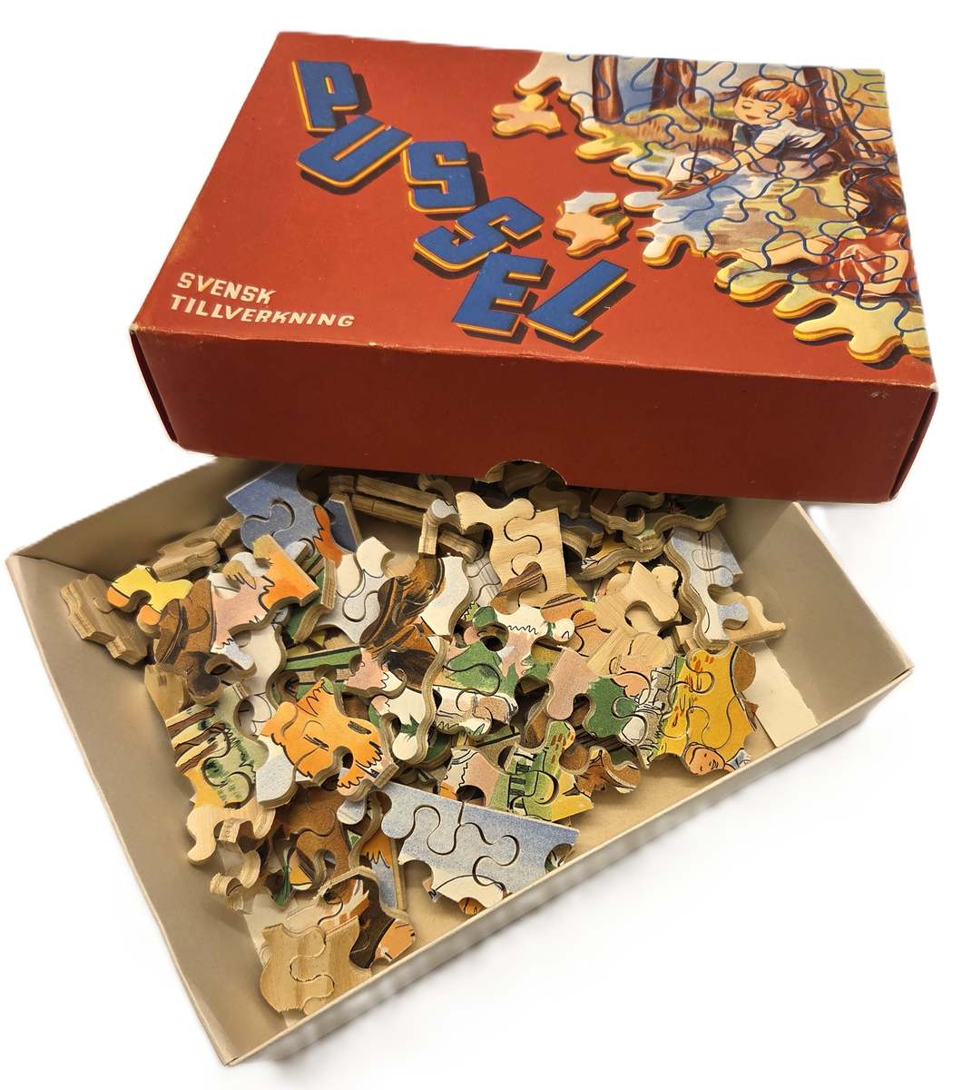 Litet barnpussel i trä. Svensk tillverkning. Pusslet är utsågat i trä och ligger i en röd pappkartong. Motiv av barn i natur.