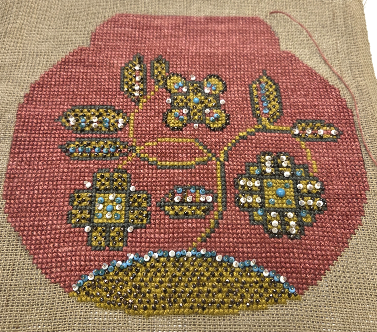 Broderi till väska. Petit point och pärlbroderi. Rosa botten med blommor och blad i gult, brunt, blått och vitt.