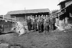 Gruppe med 13 velkledde menn, fotografert stående på oppkjør