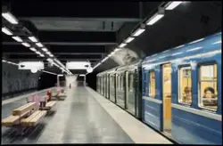Ett tunnelbanetåg med blå och gröna vagnar vid Hallonbergens