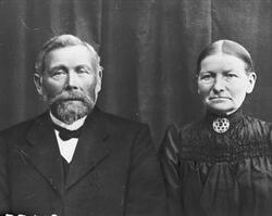 Studioportrett av et eldre ektepar.