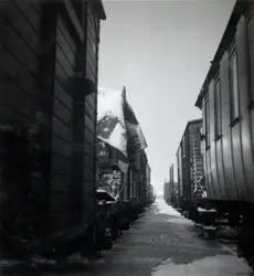 a) " Hamnen 587 " Bort mellan två rader godsvagnar. Snö på m