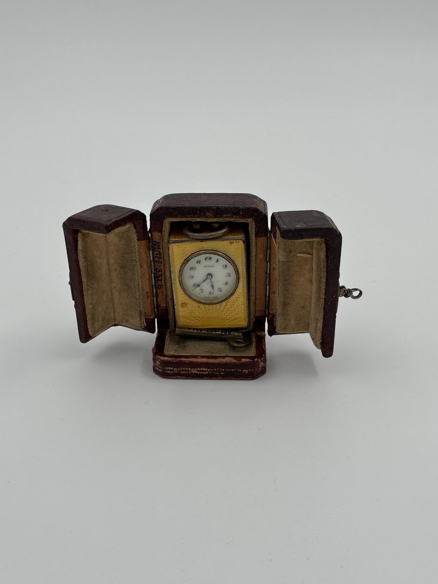 Reseur med fodral och nyckel. Rektangulär form. Boett av silver, på fyra sidor försedd med gul emalj.
Urverkets tillverkningsnummer: 162038
Boetten upptill med ögla, står på fyra runda fötter.
Fodral av läder.

Storlek: Uret: 2,9 x 1,8 x 3,7 cm.
              Fodralet: 4,3 x 4,0 x 6,0 cm.

Modell/Fabrikat/typ: Zenith