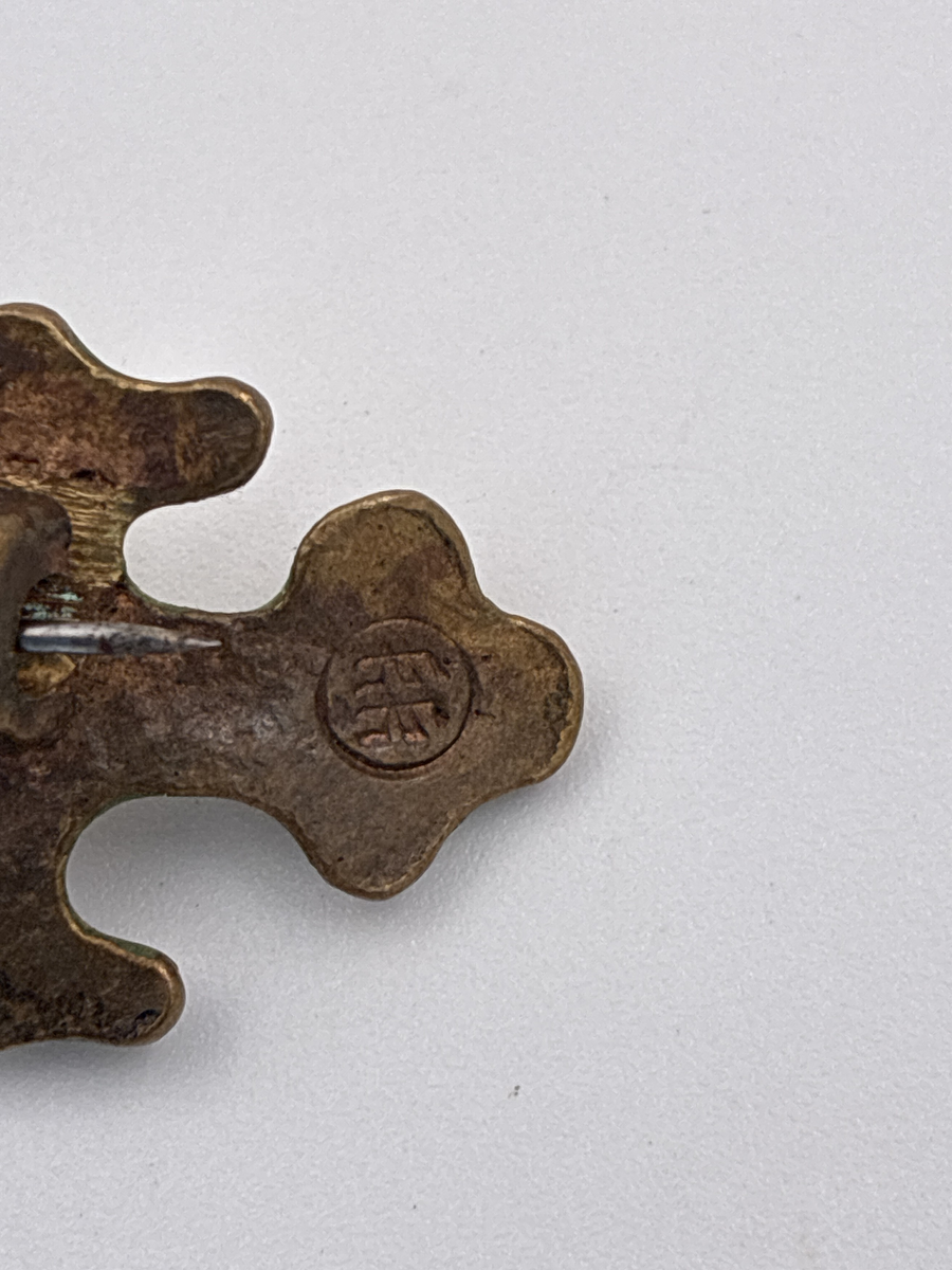 Brosch av brons. Från det finska smyckesmärket Kalevala Korus serie Oksa. Insidan stämplad KK i en cirkel.