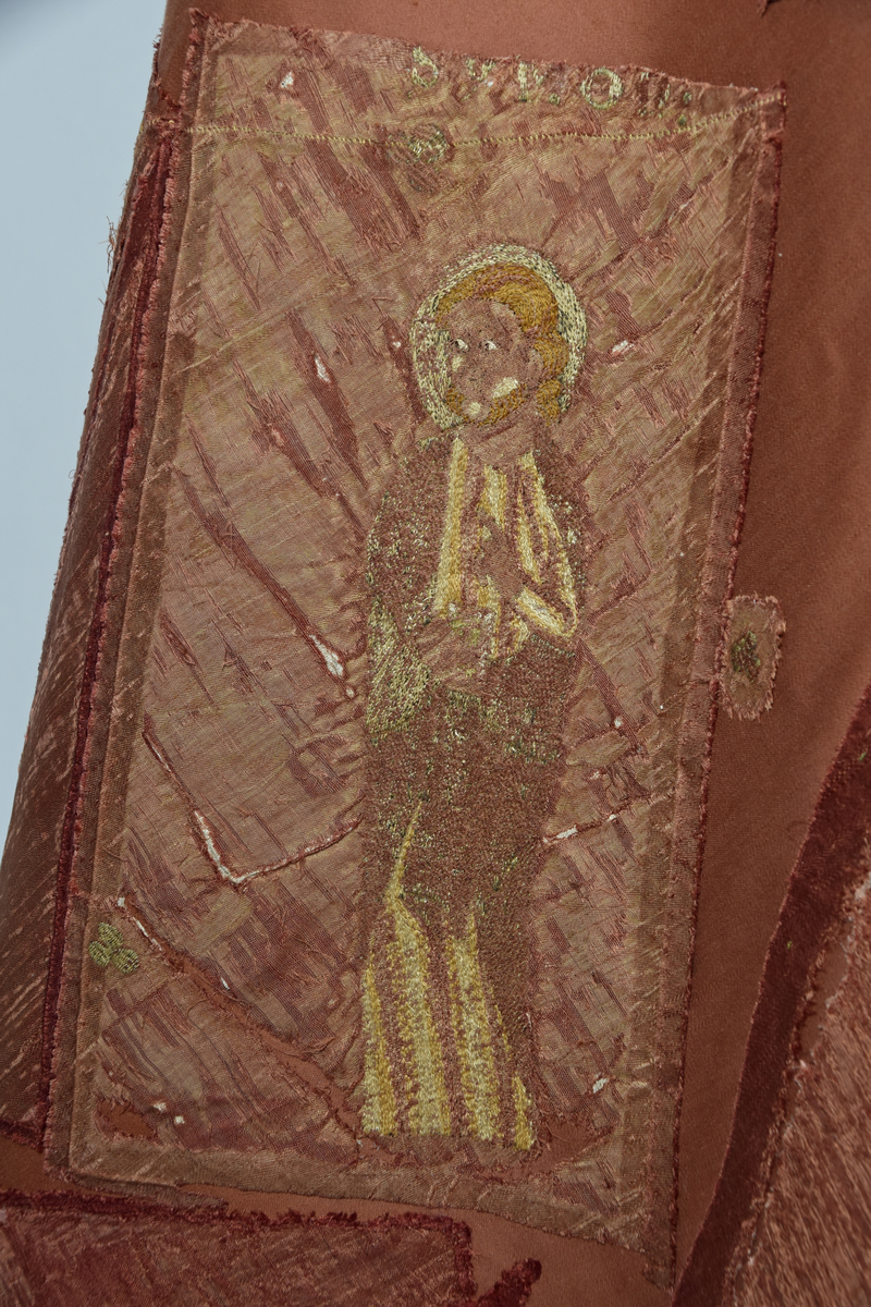 Klockformad mässhake, så kallad casula, av blåaktigt röd samitum med rektangulär halsringning. Ryggsidan prydes med en mittbård bestående av mönstervävda band, på framsidan bildar bandet ett T-kors. Ett 30-tal broderade figurer, bl a Kristus, Maria, apostlar, helgon och änglar. Varje figur är namngiven. Mellan figurerna är små klöverblad broderade, i silke och guldtråd. Mässhaken är fodrad med ofärgat linne.

Konserverad 1982-1985 av RAÄ. Hopfogad av antependium nr 1495 och mässhake 1494.

Enligt liggaren:
"Messhake, liffergad med kors framst. Jesus och Maria omgifven af apostlarne samt englakor., från 1200-talet"
Litteratur:
"Medeltida vävnader och broderier i Sverige",  A. Branting och A. Lindblom. 1928/29
"Medeltida textilier i Skara Domkyrka", Skara I, Inger Estham. 1986