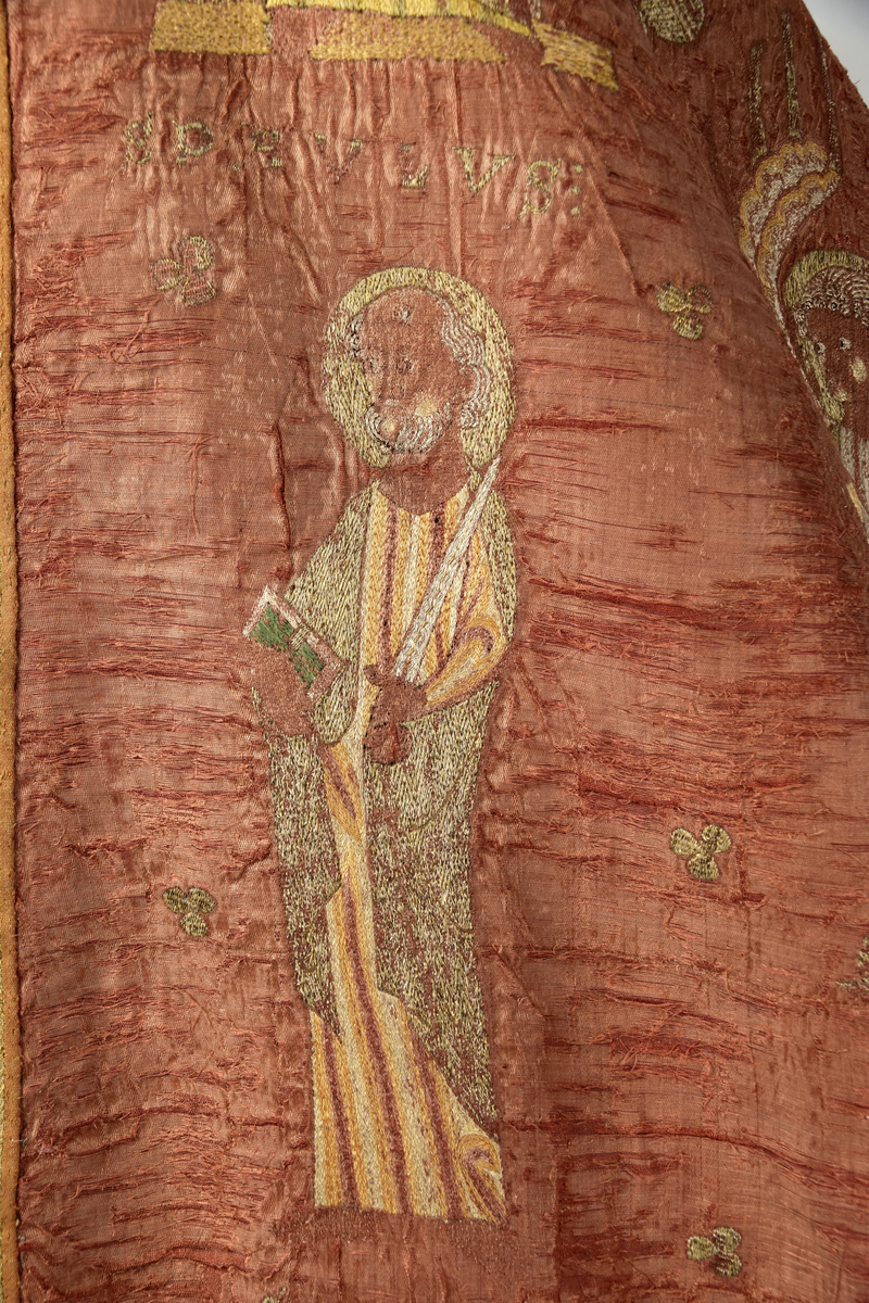 Klockformad mässhake, så kallad casula, av blåaktigt röd samitum med rektangulär halsringning. Ryggsidan prydes med en mittbård bestående av mönstervävda band, på framsidan bildar bandet ett T-kors. Ett 30-tal broderade figurer, bl a Kristus, Maria, apostlar, helgon och änglar. Varje figur är namngiven. Mellan figurerna är små klöverblad broderade, i silke och guldtråd. Mässhaken är fodrad med ofärgat linne.

Konserverad 1982-1985 av RAÄ. Hopfogad av antependium nr 1495 och mässhake 1494.

Enligt liggaren:
"Messhake, liffergad med kors framst. Jesus och Maria omgifven af apostlarne samt englakor., från 1200-talet"
Litteratur:
"Medeltida vävnader och broderier i Sverige",  A. Branting och A. Lindblom. 1928/29
"Medeltida textilier i Skara Domkyrka", Skara I, Inger Estham. 1986