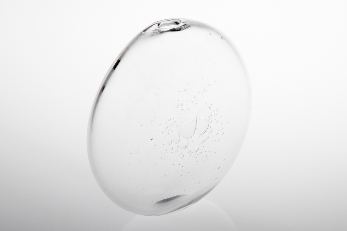 Vase i klart glass. Flattrykt kuleform med liten oval bunnflate og liten uregelmessig åpning. Uregelmessige luftbobler som dekor.