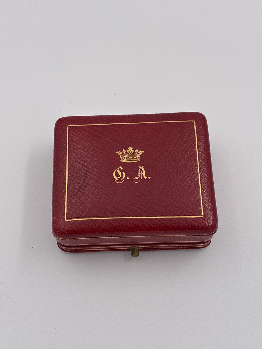 Tre svarta stanar, troligen gagat eller onyx, och två vita stenar i infattning av förgyllt silver.

Stämplar: Trekronorsstämpel
Årsbokstav: K7 (1912)
Stadsstämpel: oläslig, troligen Stockholm
Mästarstämpel " I SUNDSTRÖM" = Israel Sundström

I etui, troligen inte original till broschen, med krönt monogram C.A = Claes Adelsköld.