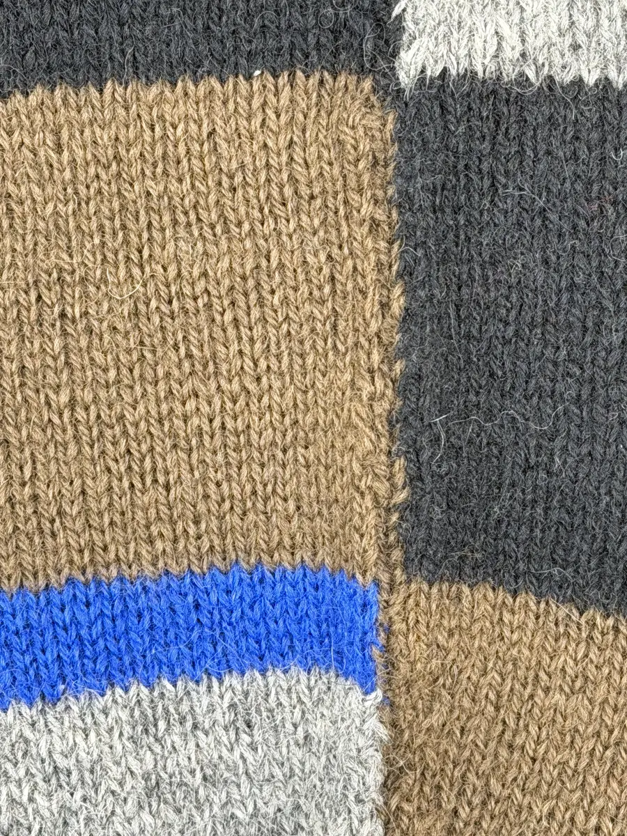 En stickad socka, med mudd i 1-1 resår (1 rät och 1 avig maska), skaft mönstrat med intarsia och fot i slätstickning, av 2-trådigt ullgarn.
