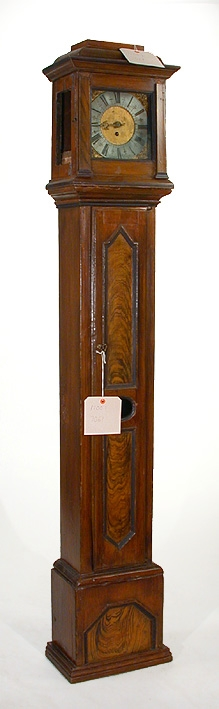 Kvadratisk formad i tre sammansatta delar med urverket överst. På mittersta delen finns en öppningsbar dörr innanför denna finns ett klocklod. Skåpet är brundmålat med dekorlister. Urtavlan är målat med romerska siffror. Huv och visare uppgives ej vara ursprungliga.