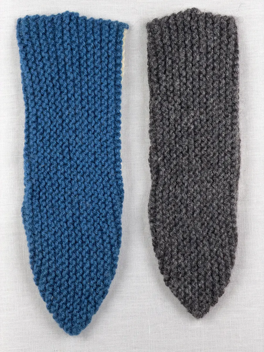 Två stickade tofflor, i slät- och rätstickning, av 3-trådigt ullgarn - Dubbelsport från Bergå Spinneri. Toffeln är hopsydd mitt fram med kaststygn och sedan dekorerad med korsstygn på rad, som ska likna en "snörning".
Gjord efter Bergå beskrivning innesockan Mysing från Bergå Färgeri & Ullspinneri, Stora Skedvi, Dalarna.