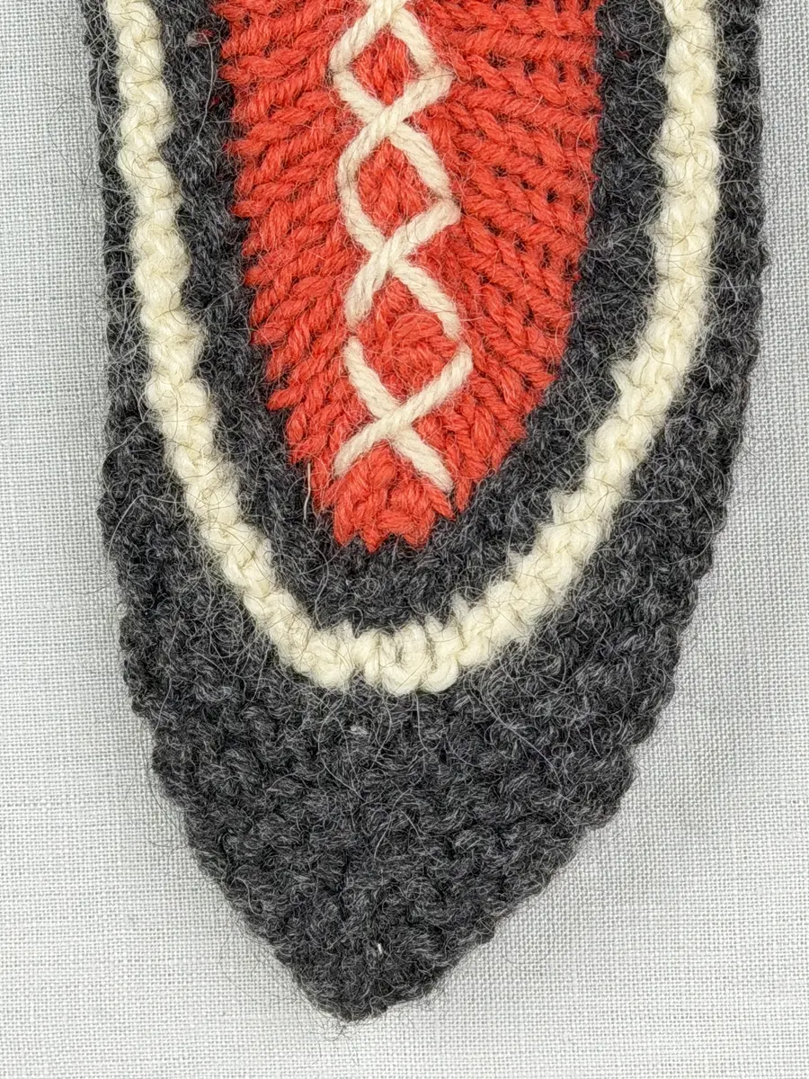 Två stickade tofflor, i slät- och rätstickning, av 3-trådigt ullgarn - Dubbelsport från Bergå Spinneri. Toffeln är hopsydd mitt fram med kaststygn och sedan dekorerad med korsstygn på rad, som ska likna en "snörning".
Gjord efter Bergå beskrivning innesockan Mysing från Bergå Färgeri & Ullspinneri, Stora Skedvi, Dalarna.