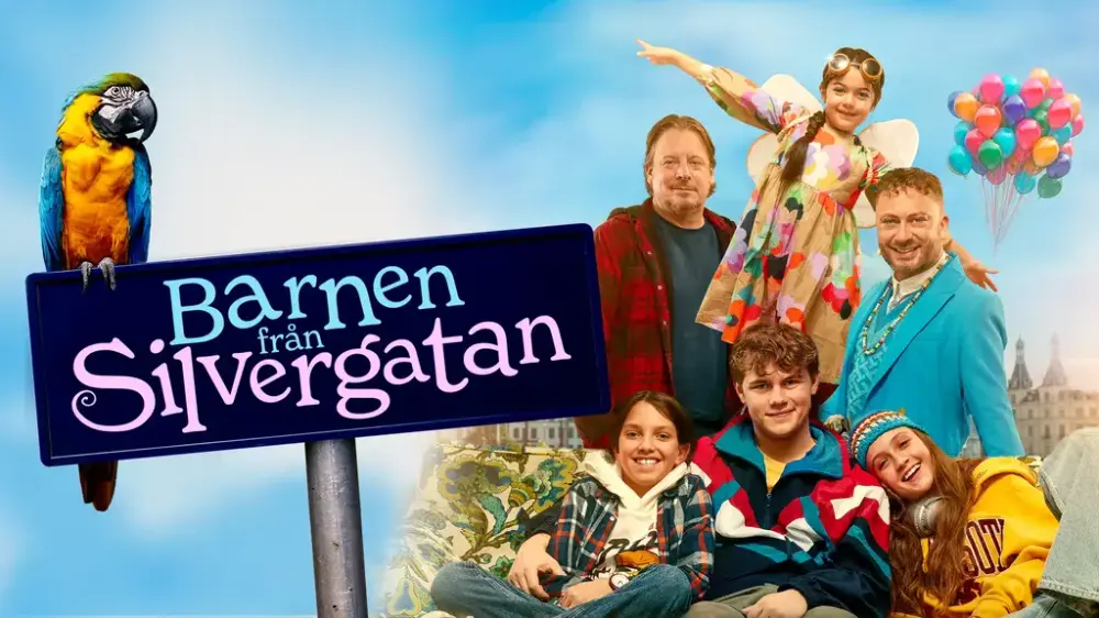 En papegoja sitter på en skylt framför en familj med sex personer och med ett knippe ballonger i bakgrunden.