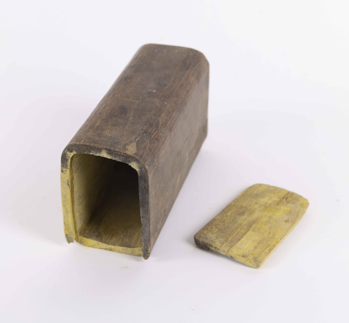 Rektangulær treeske med lokk i topp og bunn. Esken har buede hjørner og flate lokk. Lokkene kan skyves inn og ut i spor.