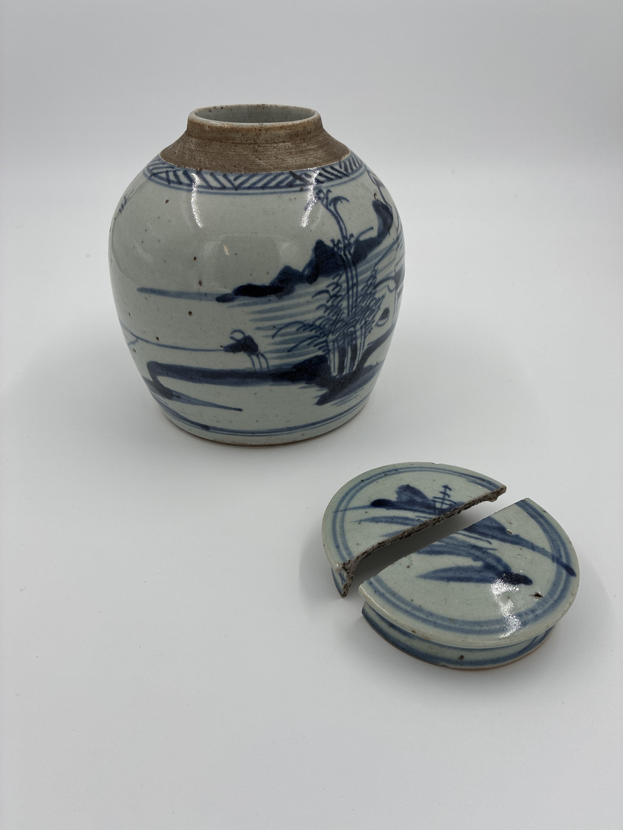 Kruka med trasigt lock. Blå dekor med hamn- och båtmotiv. Från Kina. Finns ett ytterligare lock märkt AM 302 men detta kan möjligen höra till AM 433 eller AM 434 istället.