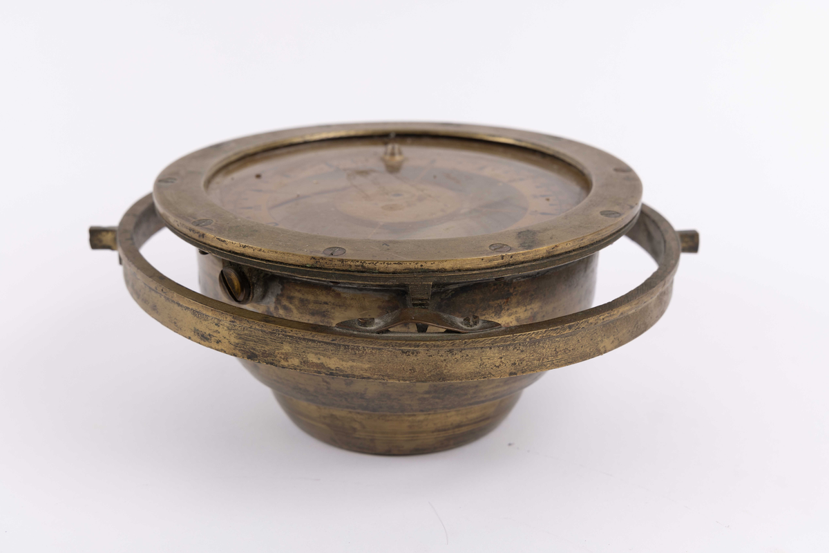 Rund lysventil med glass. Koøye med to store lukkebolter og hengsel i øvre kant. Ventil kan åpnes og lukkes.