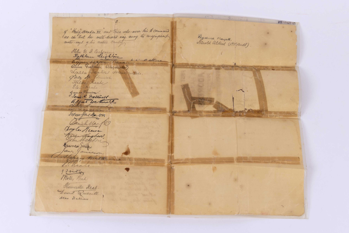 Dokument: Signert brev skrevet av passasjerene ombord på HAAKON VII i 7. juni1907 på jomfrutur. Gitt til kaptein Børre Arnet i forbindelse med overrekkelse av en sølvforgylt pyntegjenstand. Brevet er innbakt i plastomslag.