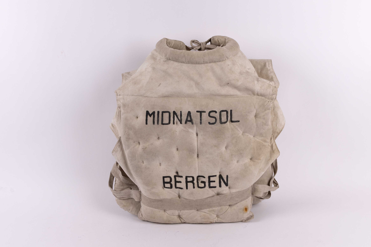 Livbelte fra DS MIDNATSOL i lerret. Livbelte er av bomullsstoff, der flyteposane er fylt med Kapok fra Kapok-tre. Med 4 stk. flyteelement i front og ett i rygg samt i kragen. Vesten har en tykk krage til nakkestøtte, front er åpen og har reimer for knyting i livet og hals.