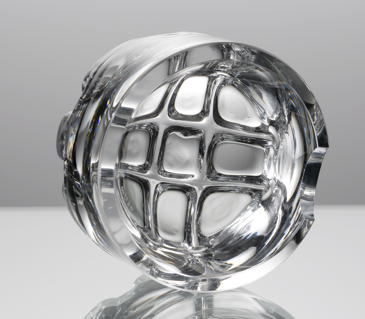 Askfat, rund form. tjockväggig med rutmönster i botten. Två nedsänkningar i kanten för cigaretter. 
Formgivare: Olle Alberius.