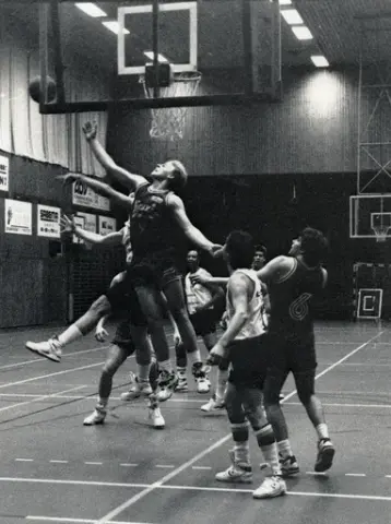 Kvarnby Basket spelar match i Mölndals idrottshus/Aktiviteten, år 1993. Motståndarlag och slutresultat är okända.