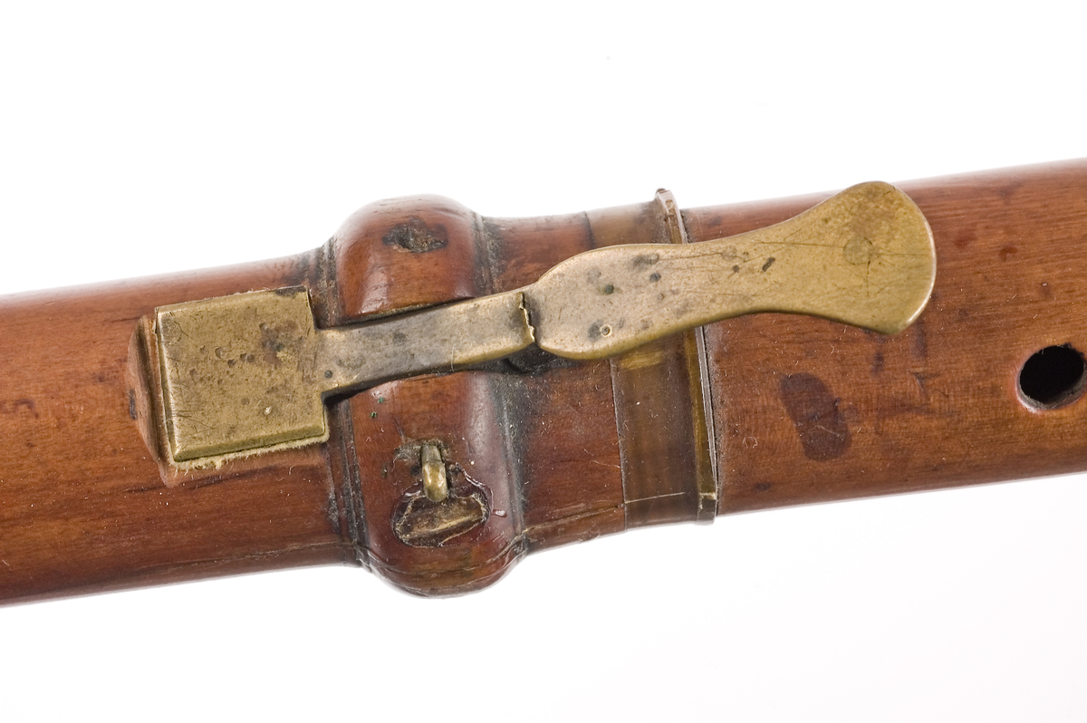 Tvärflöjt i buxbom med hornringar. 4 delar. Konisk form och svarvade vulster. Sprickor i fot och nedre mellanstycke. 1 klaff med vulstlagring och kvadratisk platta.