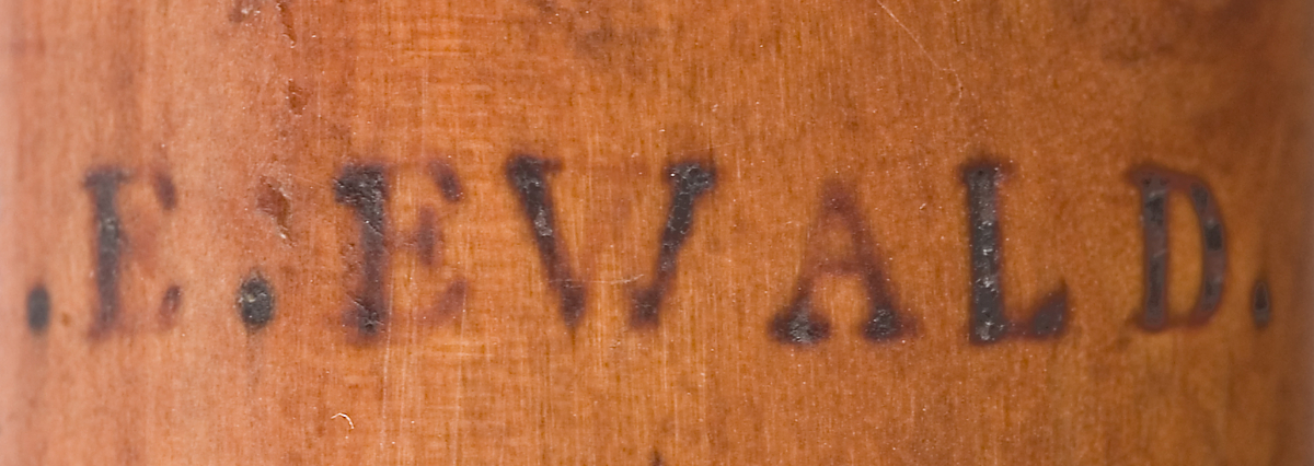 Tvärflöjt i buxbom med hornringar. 4 delar. Konisk form och svarvade vulster. Sprickor i fot och nedre mellanstycke. 1 klaff med vulstlagring och kvadratisk platta.