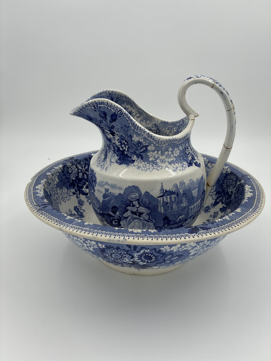 Tvättkanna med fat i blått mönster mot vit botten. Glaserat porslin från Gustavsberg.