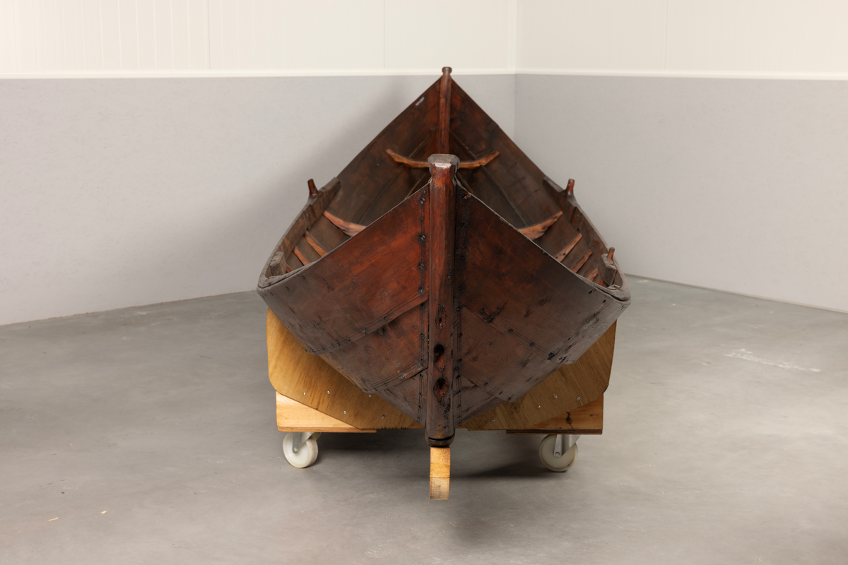 Samisk båt / skoltebask fra Varanger. Lang, smal robåt , primært for bruk i elv. Med øsekar og 2 årer.