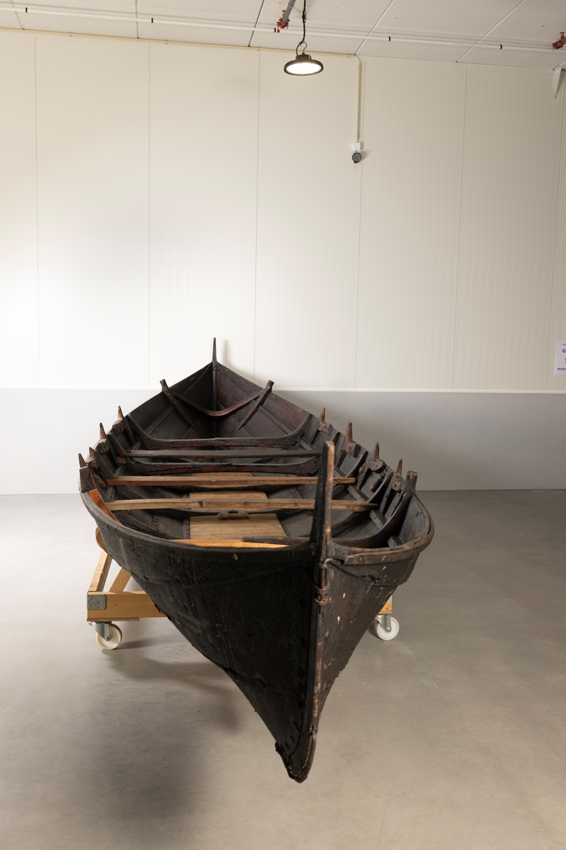 Åttring med nyere reparasjon. Fire keiper, et par årer, fem tiljer, tre tofter, ror, styrvol, mast og seil.