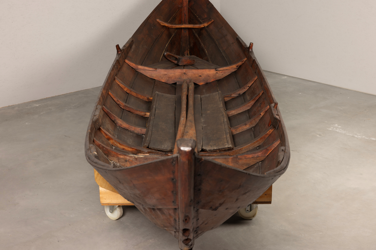 Samisk båt / skoltebask fra Varanger. Lang, smal robåt , primært for bruk i elv. Med øsekar og 2 årer.