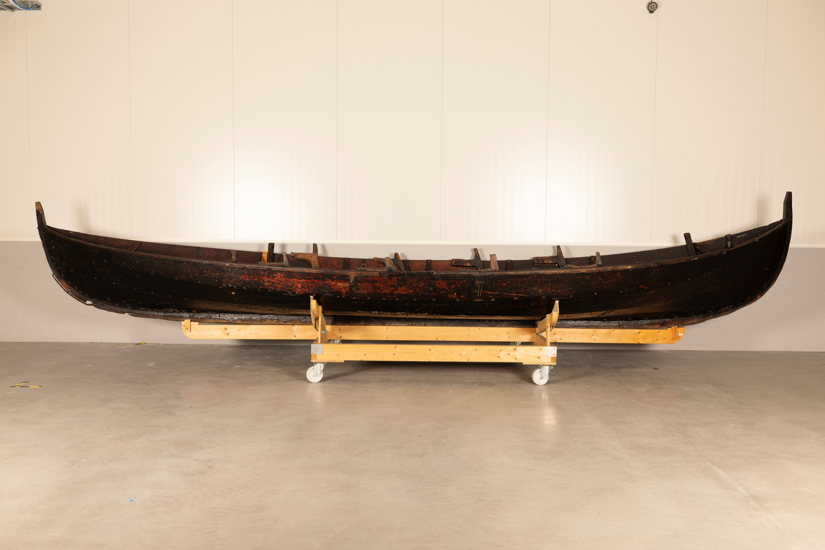 Åttring med nyere reparasjon. Fire keiper, et par årer, fem tiljer, tre tofter, ror, styrvol, mast og seil.