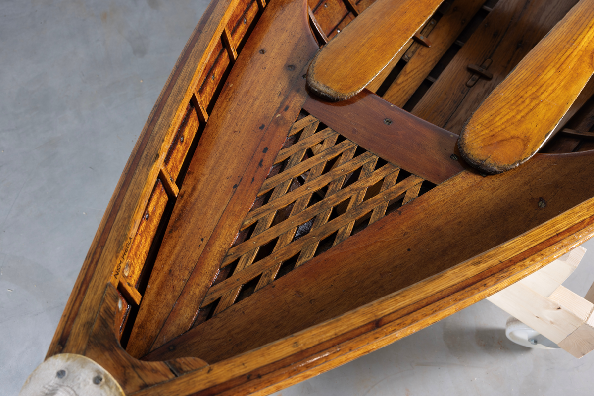 Kutterjolle med tiljer og to årer. Åregafler i metall og stoppede fendere i tekstil. Kjølen og nedre del av skroget er malt hvit.