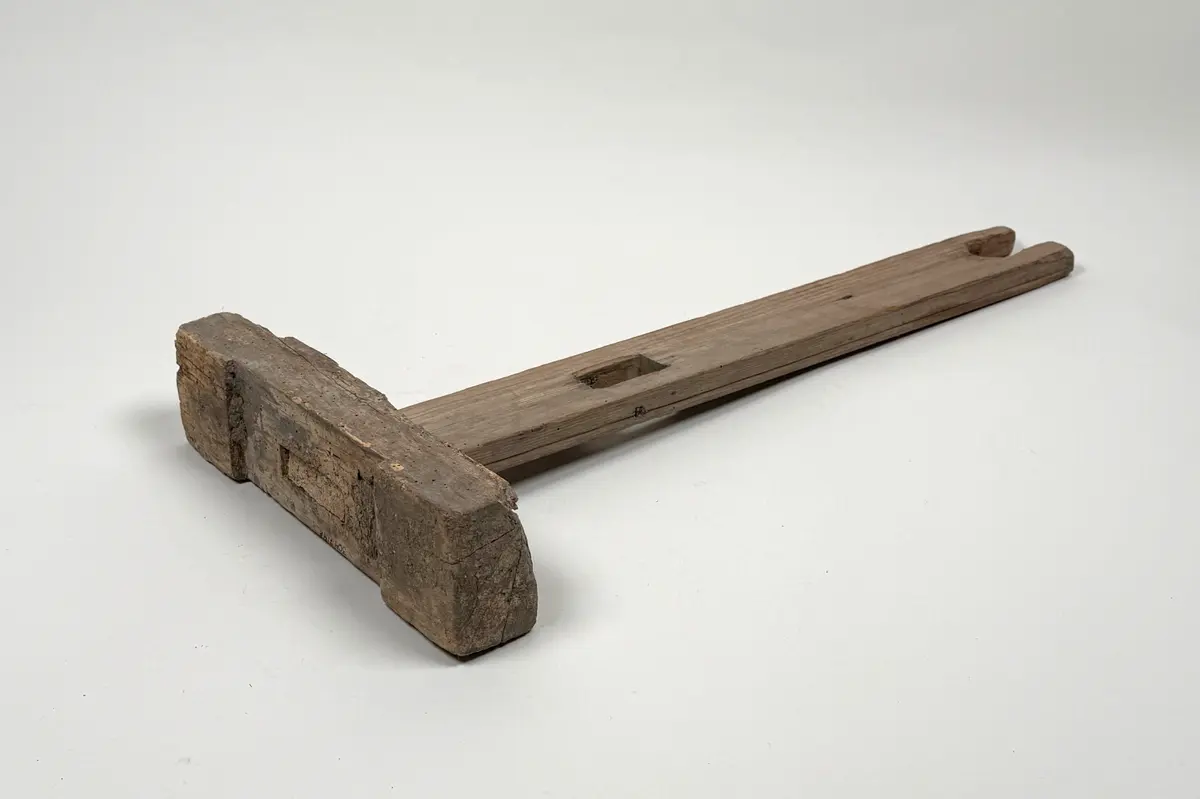 Ena benet till en benställning för bobin. Rektangulär fot med hålkärl, stående ben med fyrsidigt uttag längre ner samt U-format öppet uttag upptill. 