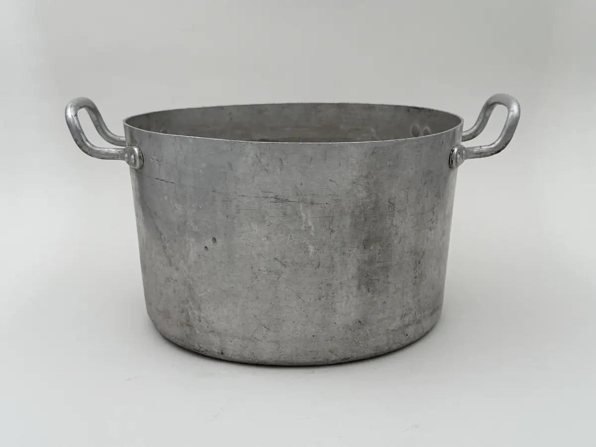 Rund kastrull av metall med två våggrepar. Stämplad Skultuna 1607 under krona samt 8L.