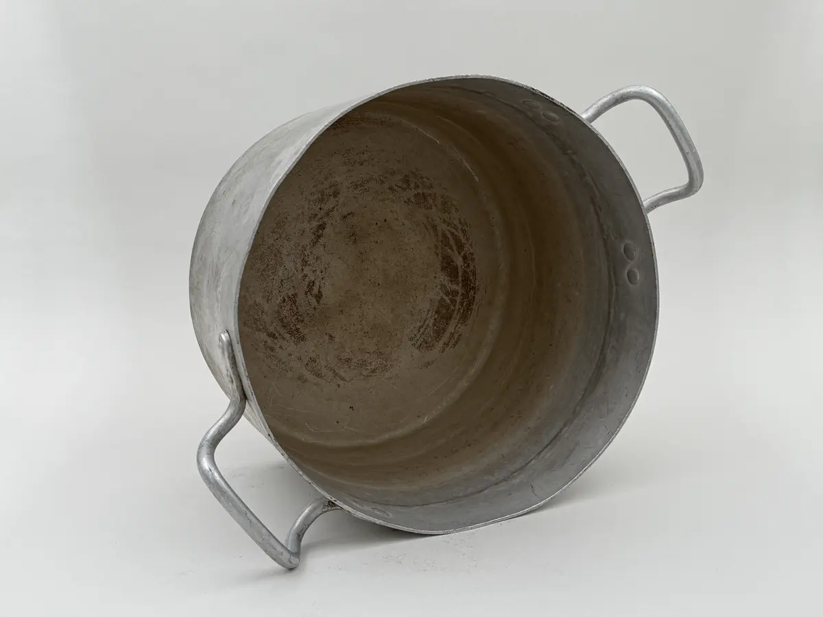 Rund kastrull av metall med två våggrepar. Stämplad Skultuna 1607 under krona samt 8L.
