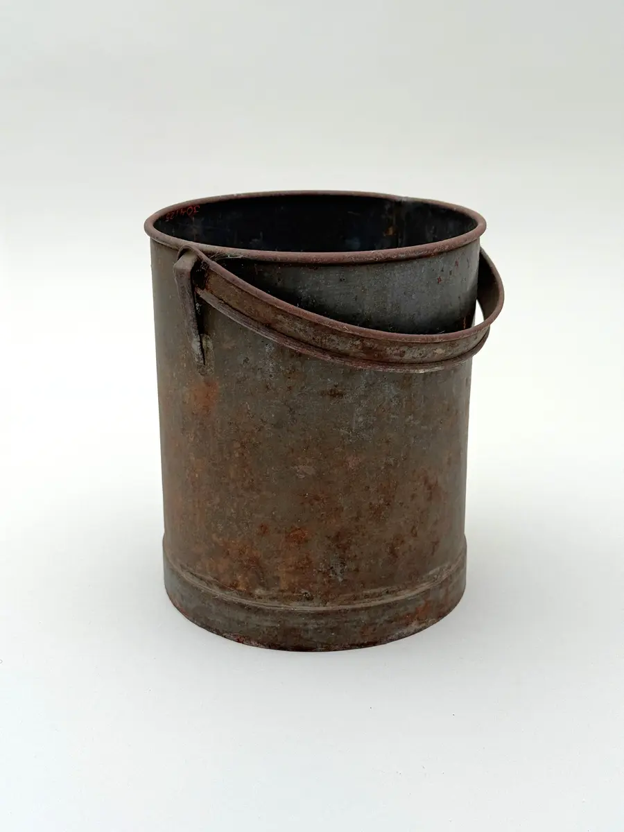Cylindrisk hink av bleckplåt med rundad mynning. Halvcirkulär grepe. 

Lock saknas.