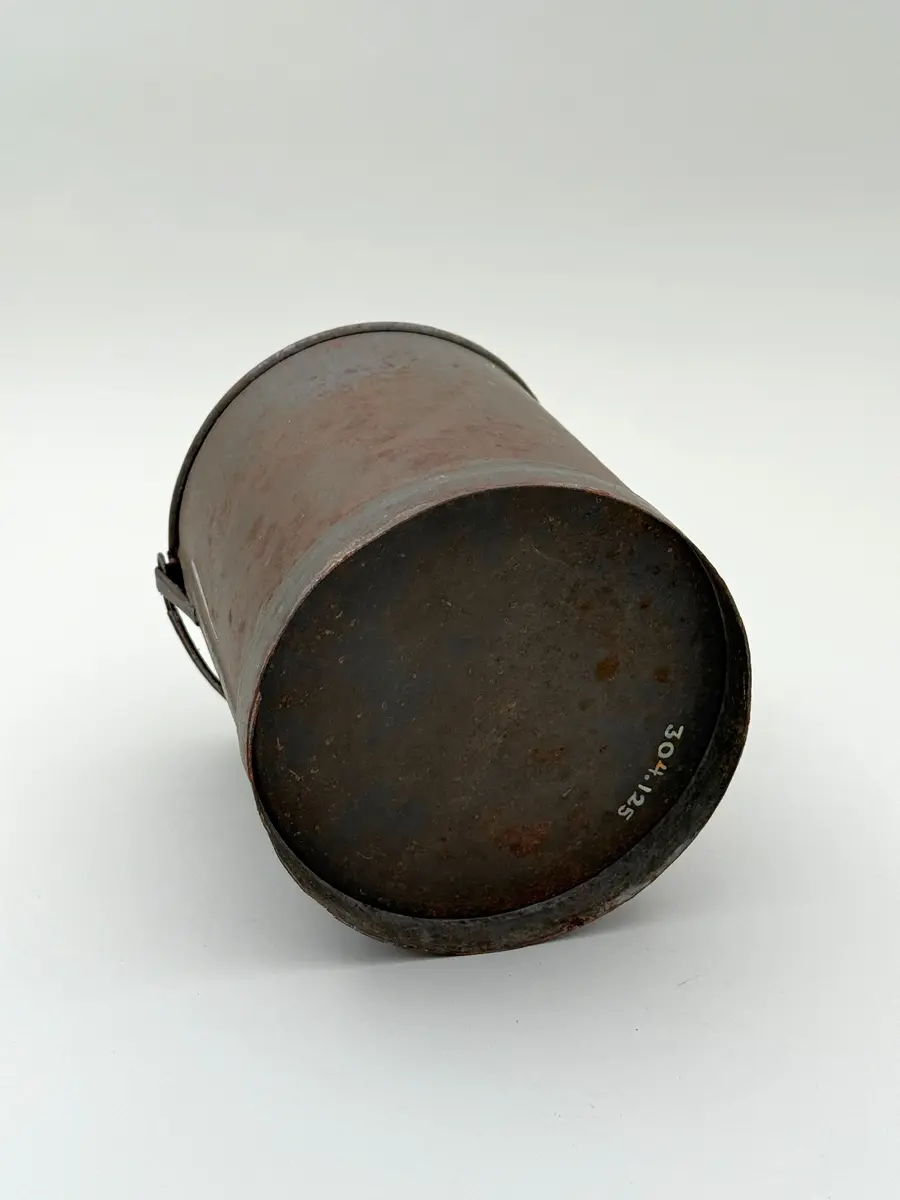 Cylindrisk hink av bleckplåt med rundad mynning. Halvcirkulär grepe. 

Lock saknas.