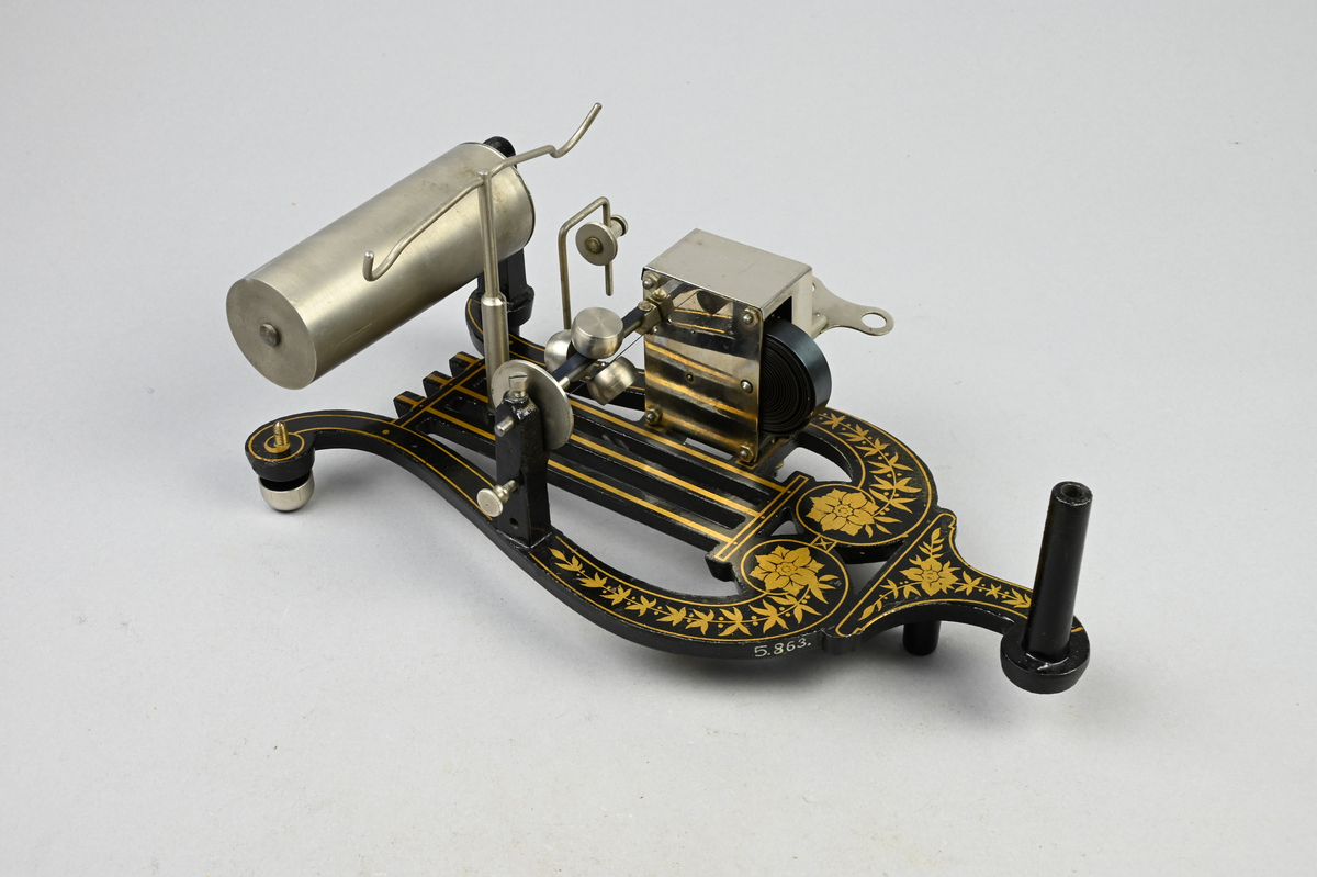 Fonograf med 6 st. vaxrullar i fodral. Fonograf med fjäderverksdriven vals för ljudrullar av Edisons mindre standardstorlek, via snörtransmission med spännare, hastighetsregulator. Konisk ljudtratt av plåt, ljuddosa med glimmermembran och stift av glas, som vid drift följer ljudspåret i rullen. Rullar av vaxmassa med 2 min. gångtid vid 160 varv/min.