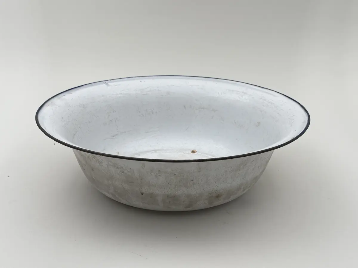 Skål av vitemaljerad plåt, utsvängd mynning, blå kant. Undersidan med frimamärke K.E.R. [Kockums Emaljerverk Ronneby] SWEDEN 32 cm. 